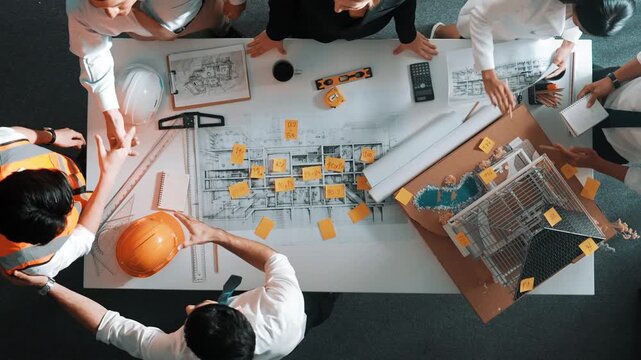 Top down view of skilled engineer team talking while looking at project plan. Aerial view of group of smart interior designer working together and planning for engineering construction. Alimentation.