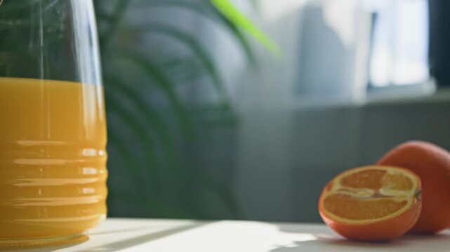 A revitalizing glass of orange juice is served with cheerful delight in a bright, sunlit kitchen