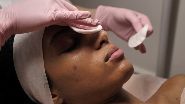 A Black woman receiving a professional facial treatment during Black History Month. Concept of inclusive beauty, self-love, and Juneteenth wellness
