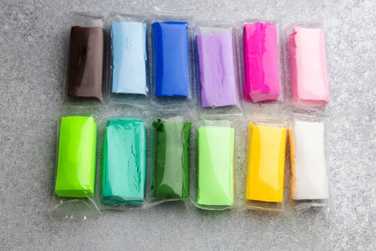 Air dry modeling clay in various colors placed on a gray surface for crafts and art projects