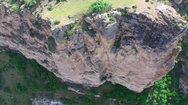 Aerial drone view reveals impressive cliff on karst limestone rocks across blue sky wilderness.