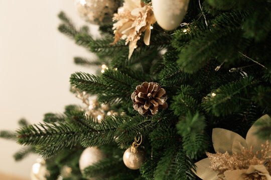 Christmas tree decoration with ornaments and pine cones in a home setting