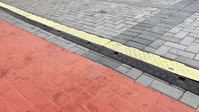 Paving block walkway with yellow and red painted safety lines