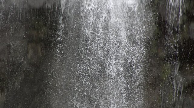 Super slow motion waterfall droplets crystallize in mid air as a cascade pours through clear spray.