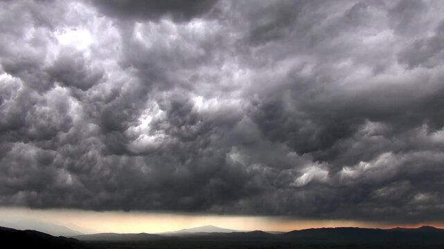 Dramatic timelapse shows dense storm clouds swirling across a dark sky during changing weather.