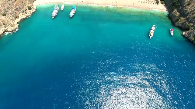 Aerial view of beach and meadow in narrow rocky rift valley on Mediterranean coast, Mugla Turkey.