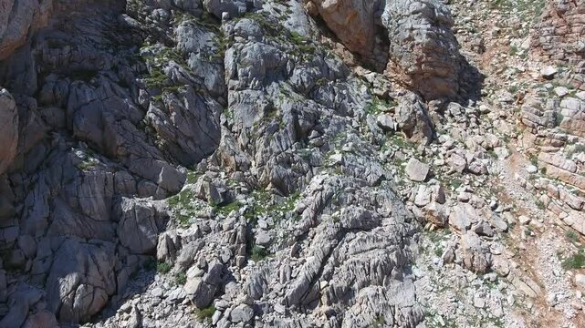 Aerial view of treeless rocky slopes across the Zagros Mountains in Iran across rugged terrain.