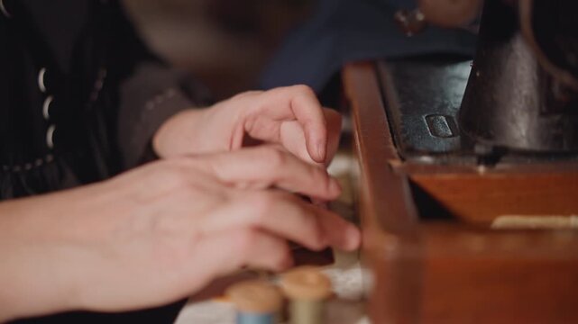 Closeup caucasian artisan preparing thread with beeswax and small wooden box, delicate fingers coating spool, tactile texture, slow ritual of thread conditioning for durable stitches.