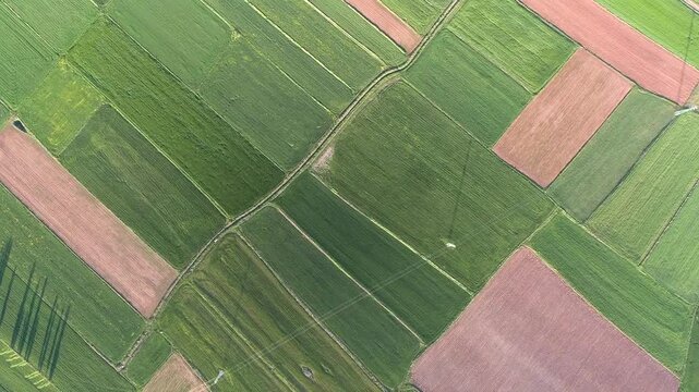 Aerial view shows patchwork agricultural farmland fields across a treeless flat plain landscape.
