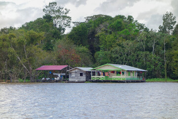 Obraz premium Floating wooden houses of riverside dwellers on banks of tropical river. nearby Manaus, Brazil
