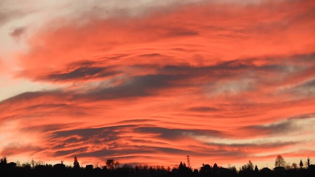 Beautiful sunset paints the sky with dense red clouds and glowing crimson layers.