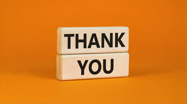 Wooden blocks spelling 'Thank You' stacked on orange background for gratitude message design