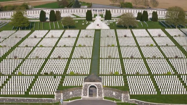 tyne cot cemetery aerial descent symmetrical view stone entrance building central path rows white wwi headstones cross of sacrifice curved memorial wall zonnebeke belgium flanders remembrance 1917