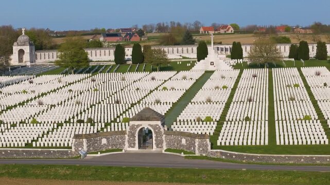 flanders war cemetery tyne cot aerial frontal view grand stone entrance aligned white wwi headstones central path curved memorial wall farmland zonnebeke belgium remembrance lest we forget 1917