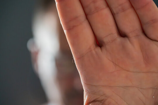 Palm of a white man with a blurred background, part of his face unrecognizable.