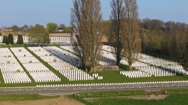 war graves cemetery tyne cot aerial close section geometric rows white wwi gravestones beneath tall trees cross of sacrifice zonnebeke belgium flanders remembrance armistice pilgrimage site 1917