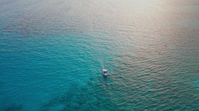 Aerial view of parasailing over the blue turquoise sea in Playa del Carmen. Drone shot of red parasail glidder soaring over Caribbean ocean in Riviera Maya, Mexico.