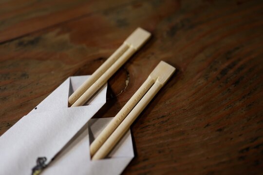 割り箸2本と紙袋。食事の準備。テーブルの上に置かれた和風食卓イメージ
