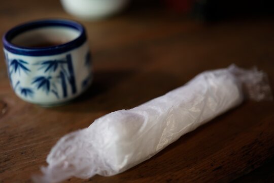 食前のおしぼり。白い紙巾着包装。テーブル上の飲食店イメージ