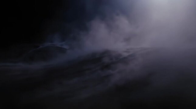 Mist rolling over dark hills at night