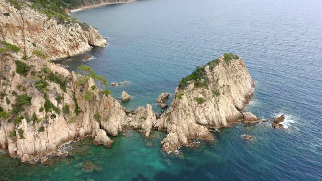 Aerial view of the viewpoint above Cala urgell y cala canyet, offering spectacular panoramas of rugged cliffs, crystal-clear Mediterranean waters and the picturesque coastline of tossa de Mar. 