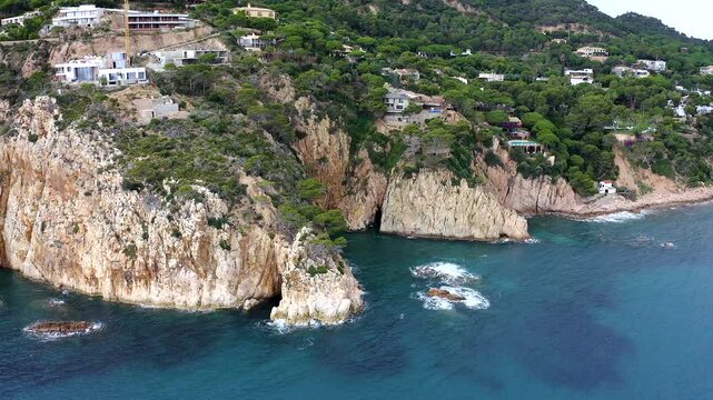Aerial view of the viewpoint above Cala urgell y cala canyet, offering spectacular panoramas of rugged cliffs, crystal-clear Mediterranean waters and the picturesque coastline of tossa de Mar. 
