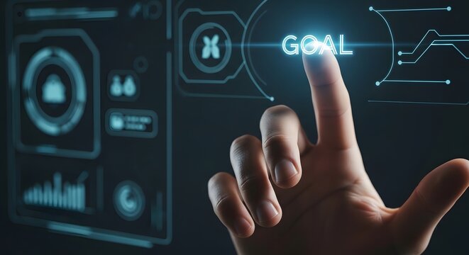 Hand pressing illuminated virtual goal interface featuring futuristic digital hud graphics and navigation elements representing achievement and strategic planning in interactive workspace environment.