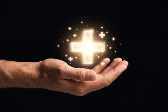 Male hand holding glowing digital plus sign symbol surrounded by small stars