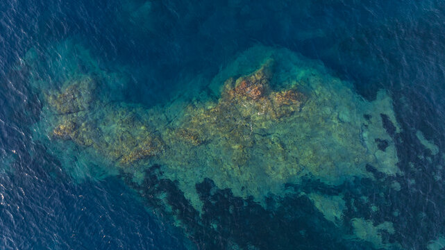 Top down aerial view of crystal clear Mediterranean waters over underwater rocks on the Esterel coast, France