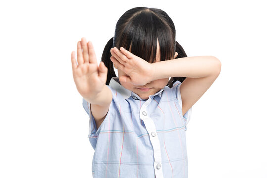 Little girl gesturing stop and covering eyes in fear, child protection and emotion concept