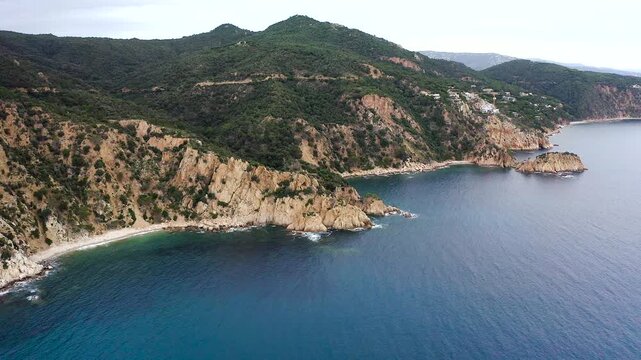 Aerial view of the viewpoint above Cala urgell y cala canyet, offering spectacular panoramas of rugged cliffs, crystal-clear Mediterranean waters and the picturesque coastline of tossa de Mar. 