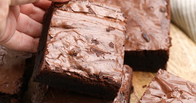 Woman putting piece of tasty brownie on table, closeup