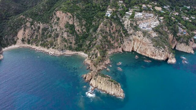 Aerial view of the viewpoint above Cala urgell y cala canyet, offering spectacular panoramas of rugged cliffs, crystal-clear Mediterranean waters and the picturesque coastline of tossa de Mar. 