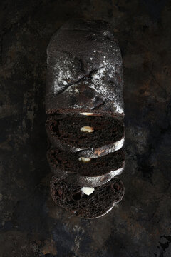 Artisan Bread Still Life. A fresh baked and sliced loaf of chocolate bread with cream cheese filling on a baking sheet.