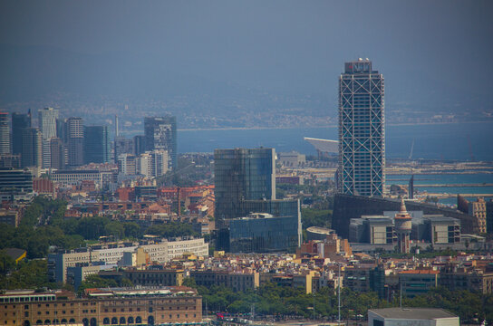 Agosto 2026. Vista con calima del litoral de Barcelona con edificios de Villa Ol&iacute;mpica y Forum.