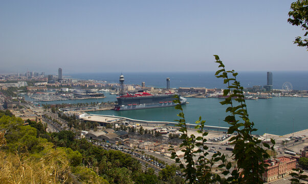 Agosto 2026. Crucero de Virgin atracado en el puerto de Barcelona. Vista general del muelle y parte del litoral.