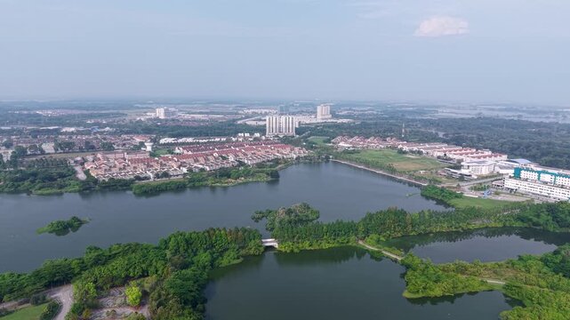 Aerial view of a large lake with islands. Green trees and grass surround the water at Kampar, Perak