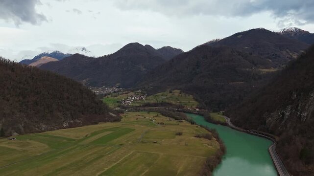 Most na Soči, Slovenia, with Ladja Lucija on the emerald Soča River amid the Soča Valley, snowy Julian Alps, forests and village landscape, viewed by drone in winter.
