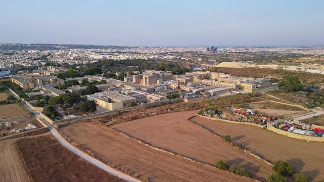 Attard, Malta, Mount Carmel Hospital psychiatric and mental health facility with surrounding residential greenery and roads in summer daytime aerial view.