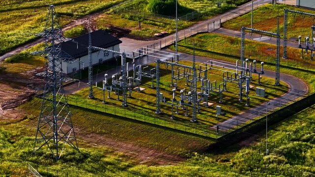Aerial view of a high-voltage substation with tall pylons for electrical power distribution