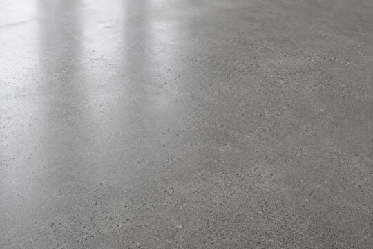 Polished grey concrete floor surface texture with light reflection