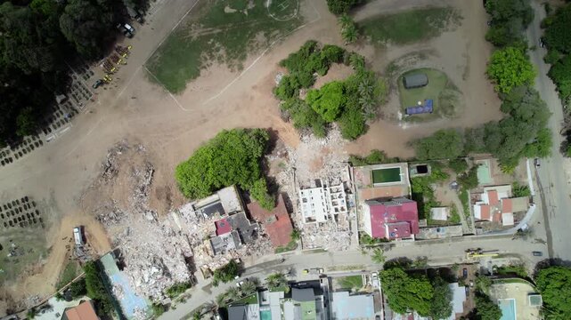 Drone footage reveals destroyed residential urban sectors and temporary morgues in parking parking lots and cleared areas near disaster zones to centralize recovered bodies and rubble in Venezuela