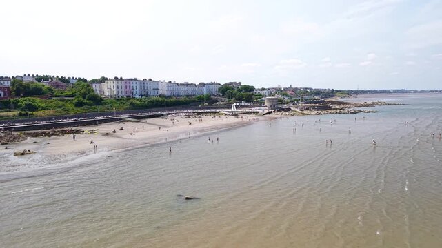 Seapoint beach in Dun Laoghaire with people enjoying sunny day in Dublin, Ireland. Drone