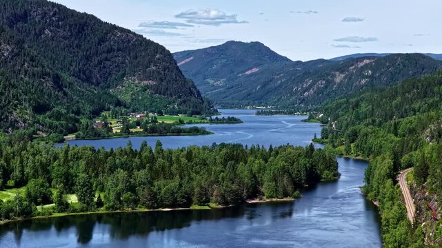 Traveling Through Peaceful Roadside Scenery With Crystal-clear Waters, Dense Pine Forests, and Majestic Mountain Valleys Along the Road From Fl&aring;m to Oslo, Norway - Orbit Drone Shot
