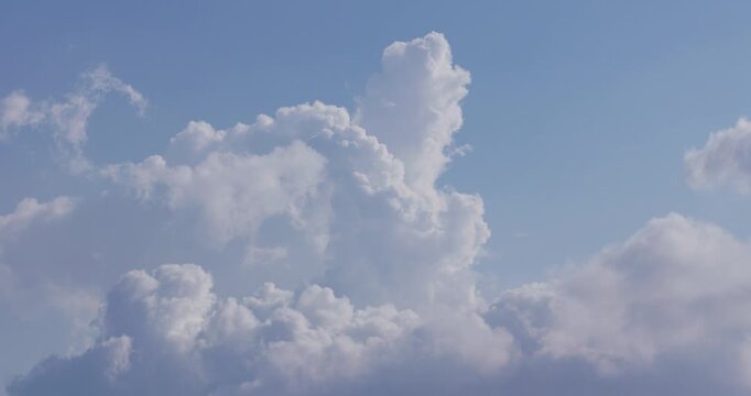 Time lapse of heavenly 3/4 backlit clouds in motion, with a blue sky background