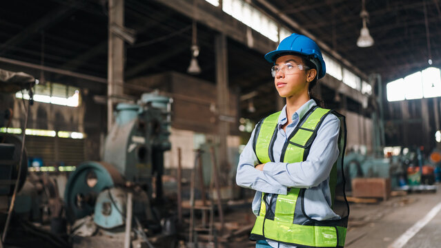 Engineer safety helmet vest factory worker woman industry workshop machine confident engineer wearing safety helmet and reflective vest standing factory workshop with machine equipment