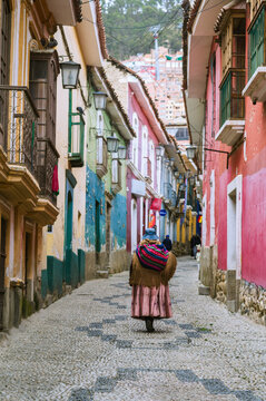 Woman in traditional dress on a colonial cobblestone street in La Paz, Bolivia