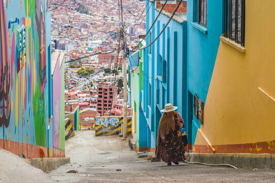 Cholita woman walking through a colorful street in La Paz, Bolivia