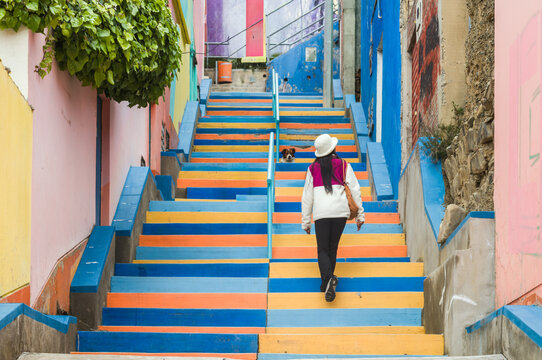 Woman climbing colorful painted stairs in La Paz, Bolivia