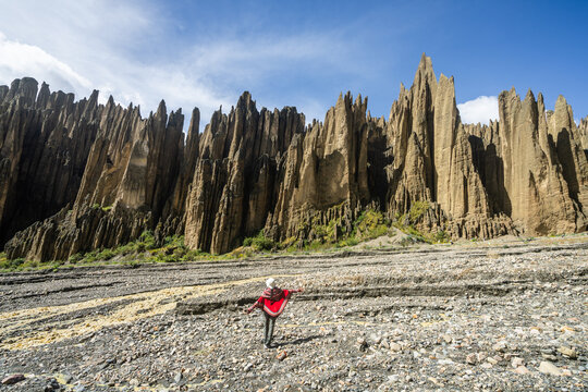 Woman with ponchi among the rock pinnacles of the Valle de las Animas near La Paz, Bolivia